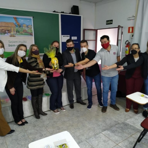 Registro do momento da entrega simbólica de uma pelúcia que é a mascote do programa